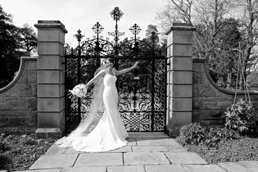 bride posing in front of iron gates