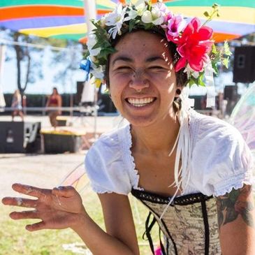Smiling woman with flower crown at an outdoor event.