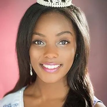 Portrait of a smiling beauty queen wearing a crown and sash.