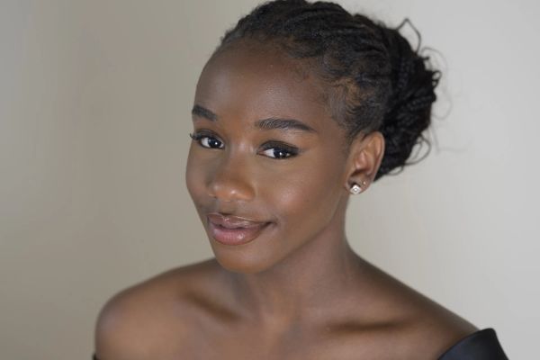Young woman with braided hair and a gentle smile.