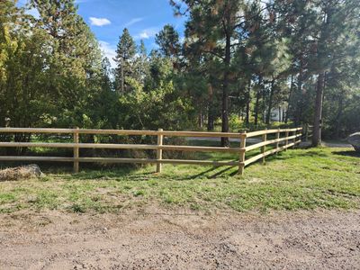 A professional crew performs farm fence installation using a heavy-duty CAT track steer.