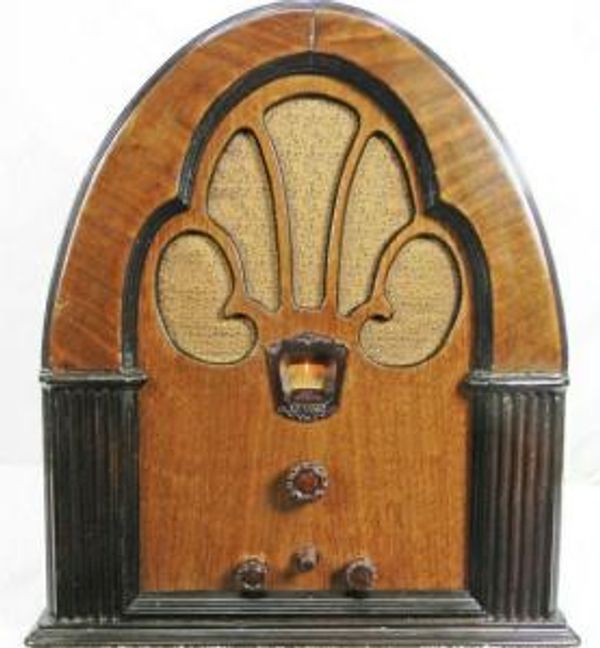 Vintage wooden cathedral-style radio with ornate speaker grille.