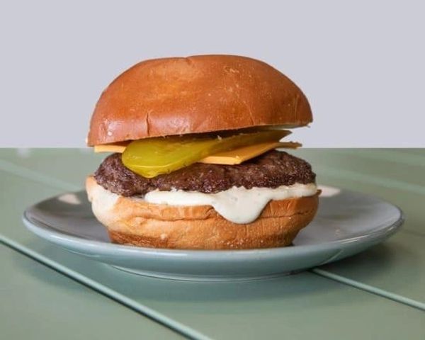 Simple cheeseburger with pickles and sauce.