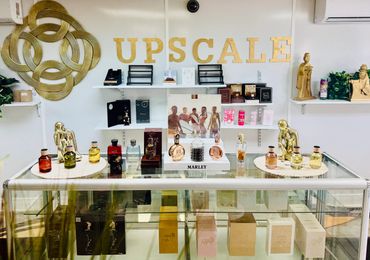 A classy display of luxury perfumes under the sign 'UPSCALE'.