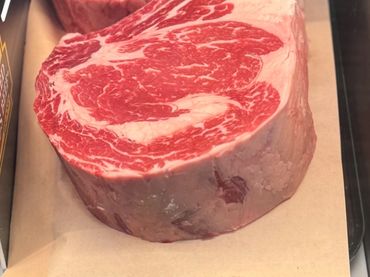 Thick, marbled prime tomahawk ribeye steaks on display.