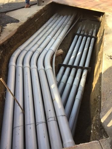 Underground pipes containing electrical wiring open trench excavation installation