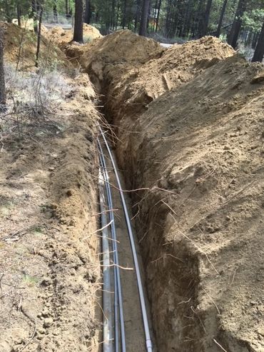 Open trench with underground wiring being installed