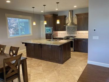 Residential kitchen with sleek minimalist recessed lighting and hanging pendant lights over island