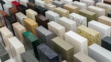Variety of stone and quartz countertop samples in different colors and patterns.