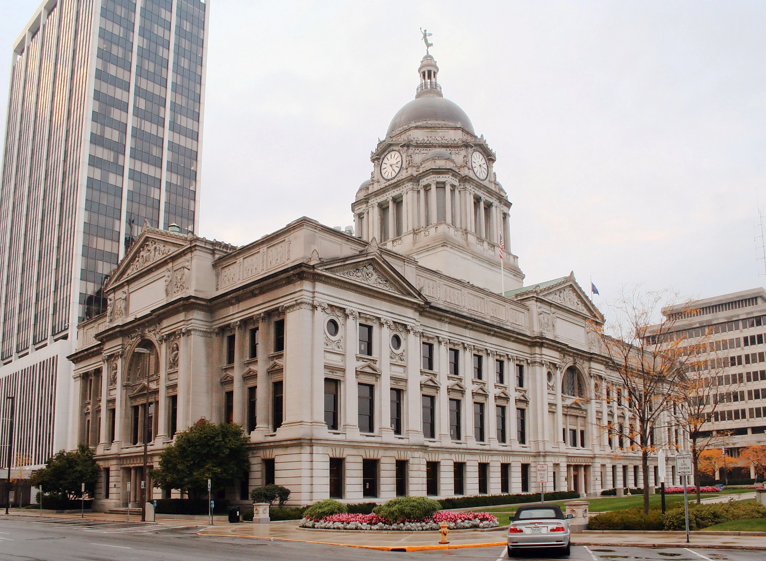 Historic courthouse with a domed clock tower in a downtown area.