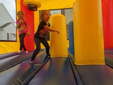 Two sisters enjoying some rough play inside of the Castle Bounce House!