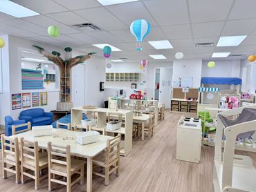 Bright and playful classroom with wooden furniture and colorful decorations.