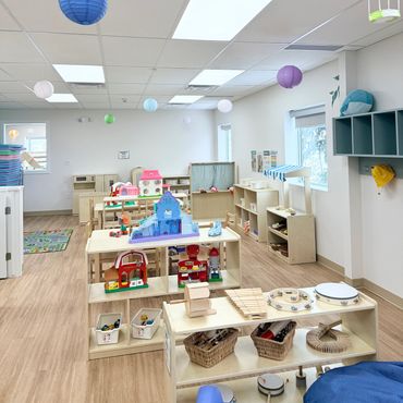 Bright and organized preschool classroom with toys and colorful hanging lanterns.