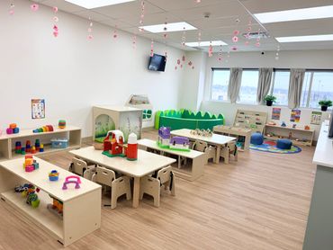 Bright and colorful early childhood classroom with toys and learning materials.