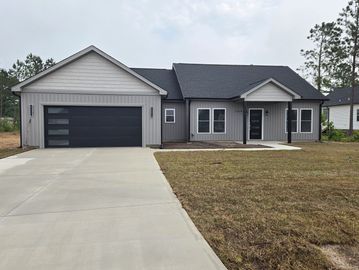 Modern single-story gray house with a two-car garage and a spacious driveway.