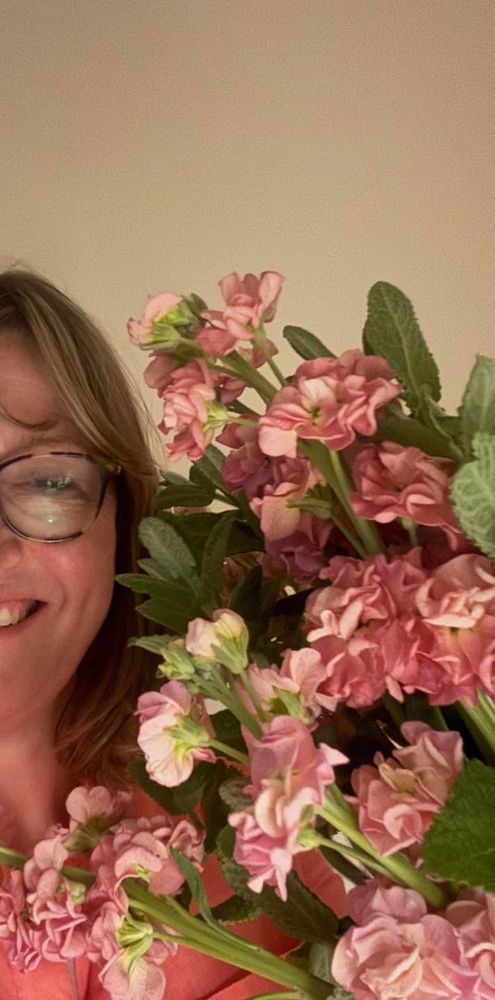Floral designer Caroline holding some peachy pink stock flowers