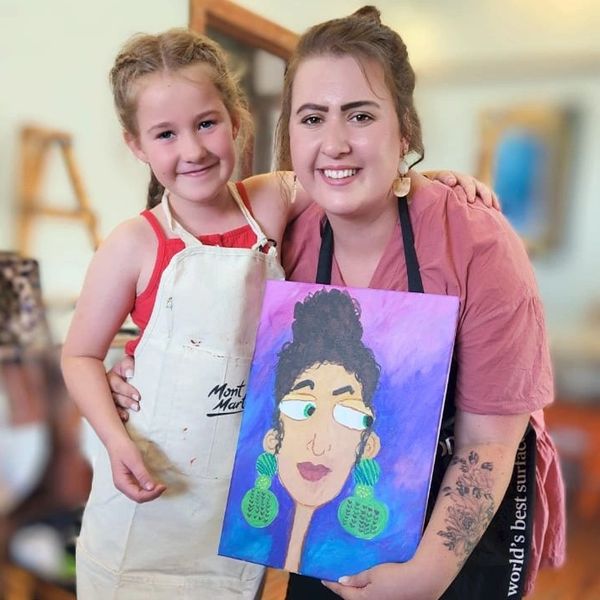 Photo: Sonette and student, with her artwork: Portrait of my teacher