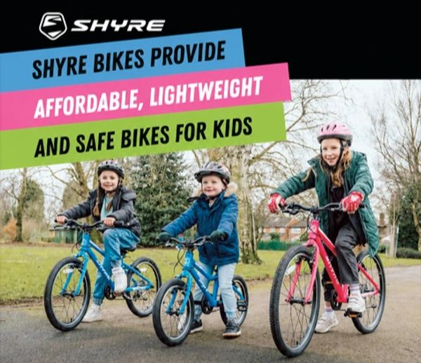 Kids riding colorful Shyre bikes outdoors with helmets on.