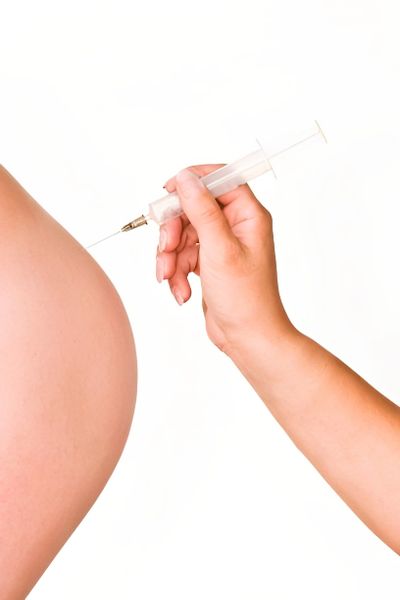 Hand performing a body injection.