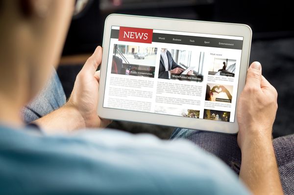 Online news article on tablet screen. Electronic newspaper or magazine.
