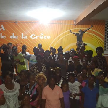 Children standing at the Hosanna Helping Hands banner