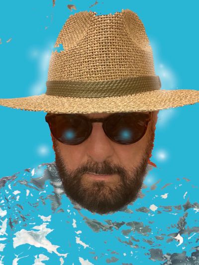 Man wearing a straw hat and sunglasses with a blue abstract background.