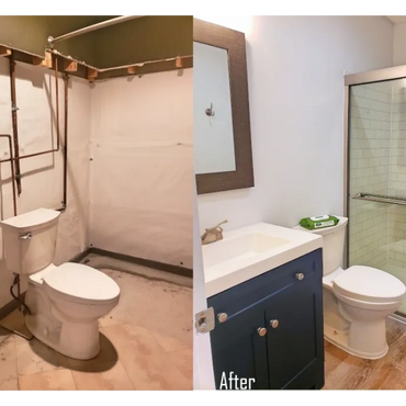 Remodeled basement bathroom with modern navy vanity, walk-in shower, gray walls, and cinnamon LVP fl