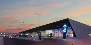 Modern airport terminal T4 during sunset with clear skies.