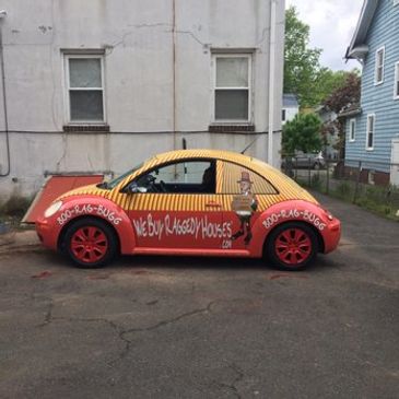 Colorful Volkswagen Beetle advertising a house buying service.