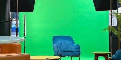 Décor de studio avec écran vert, chaise moderne et éclairage de cinéma