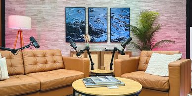 Décor de studio haut de gamme incluant sofas, microphones et écrans intelligents.