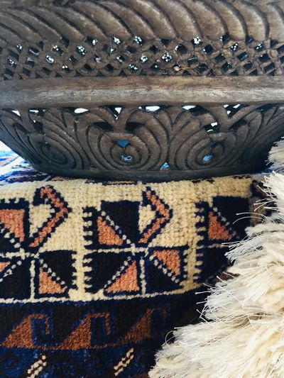 Tribal rug, round metal vase, white shag
