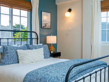 Cozy bedroom with blue patterned bedding and warm lighting.
