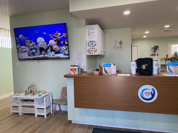 childrens area of the lobby with small table and chairs with activity center and tv