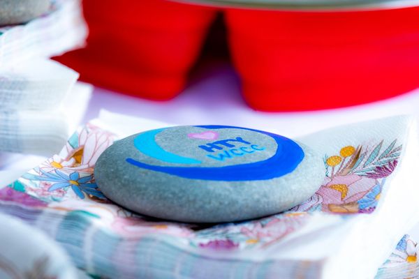 A smooth stone with the logo and "HTY WCCC" painted on it.