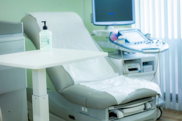 welcoming patient exam room with guest chair, hand sanitizer, sink, and more