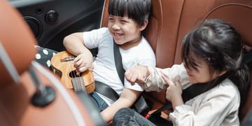 Kids sitting in the back seat, kids riding safely in the car, kids enjoying the car ride