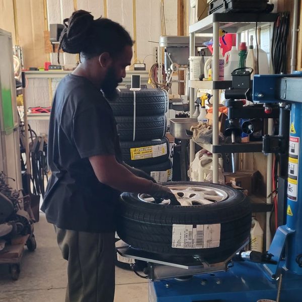 Technician mounting and balancing a tire at Your Automotive Solution in Ave Maria Naples Florida aut