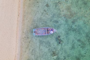 Couple lying on a traditional pirogue in Mauritius - Drone photography