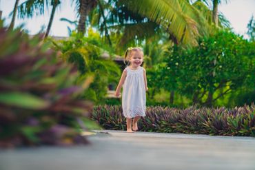 Little girl with white dress running across the pathway at LUX* Le Morne - Photographer Mauritius