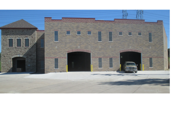 multi textured 2 story concrete block building with red edging. multiple sized windows, doors and g