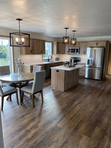 Modern kitchen with wooden cabinets, island, and dining area.