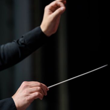 Conductor's hands holding a baton.