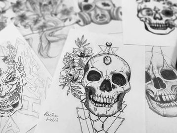 Close up image of a drawing of black and white skulls with flowers on the side of them. 