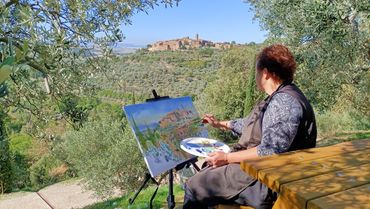 a person painting the scenery in front of them