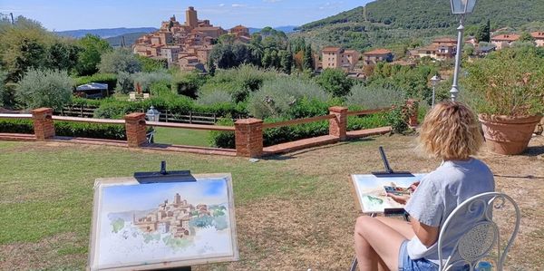 a woman painting the scenery in front of her