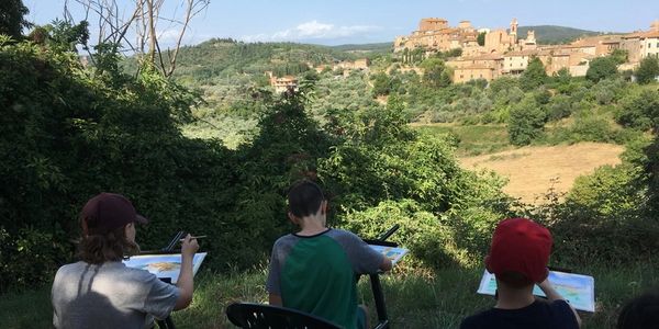 three people seated while painting