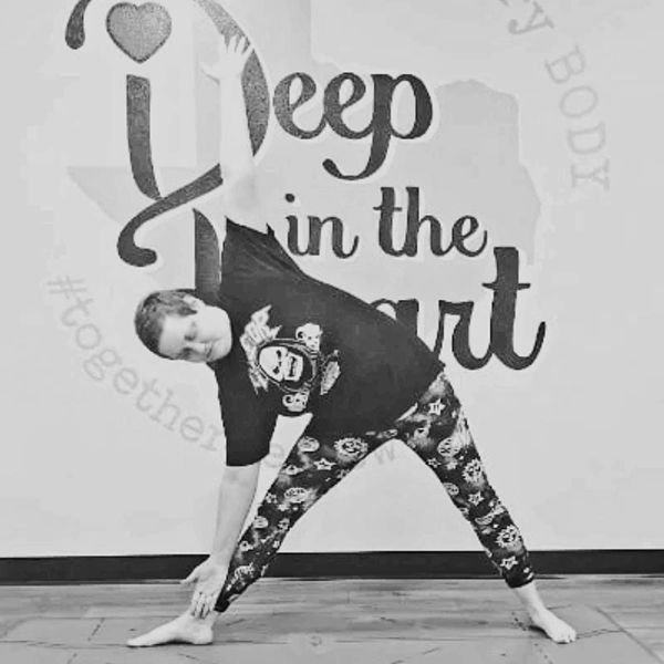 Person doing a yoga triangle pose in front of a motivational wall.