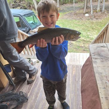 Young boy proudly holding a large fish.