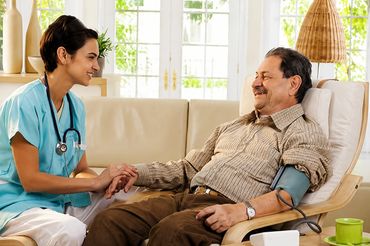 Caregiver sitting with senior patient.